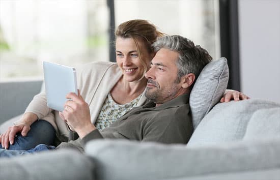 Happy older couple smiling computer